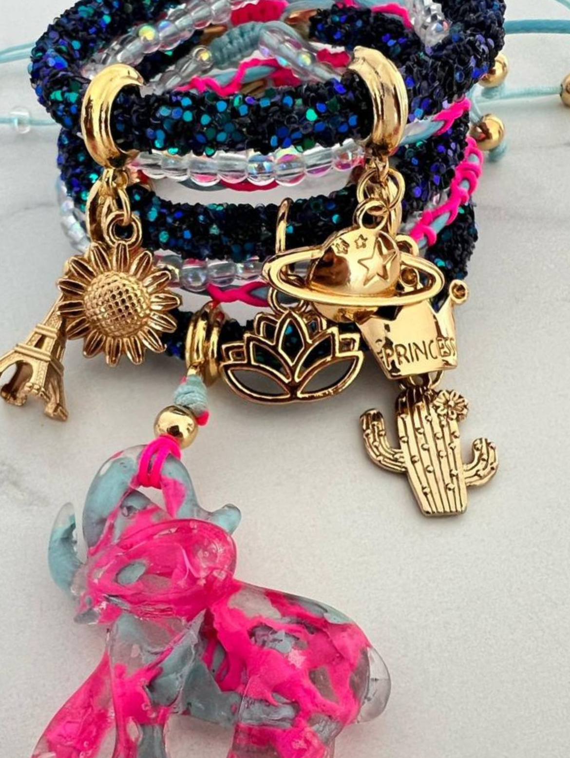 Dunkelblaues Strassarmband, hellblau-pinker Elefant und goldene Glücksbringer