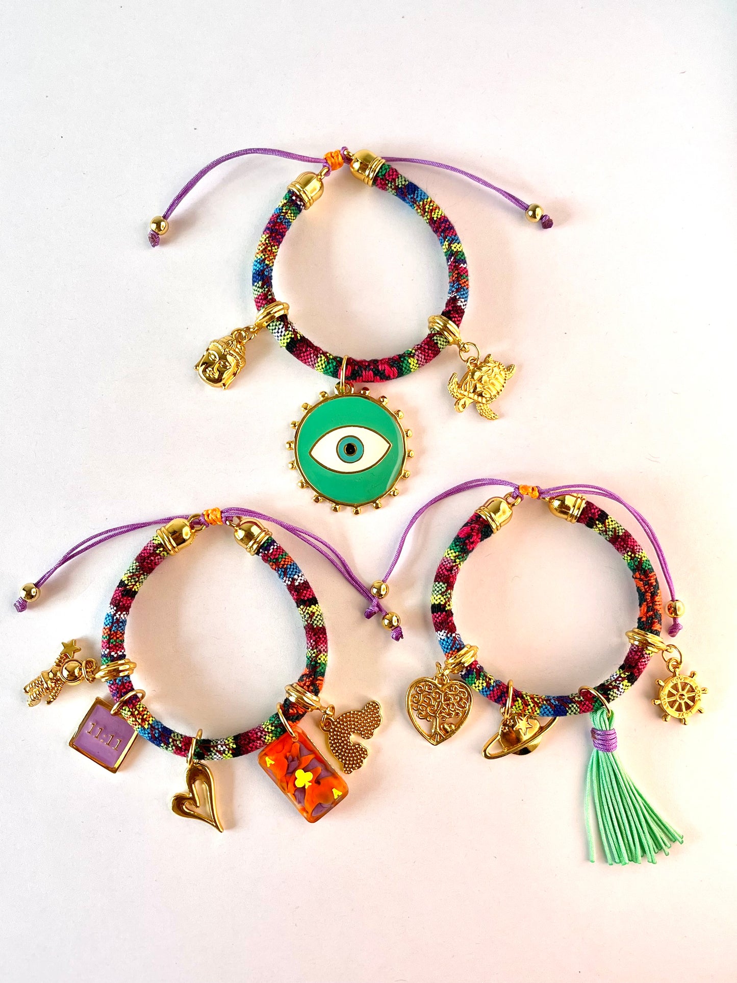 Multicolour bohemian bracelet with green evil eye charm worn on wrist, side angle view – IsabellaByShop