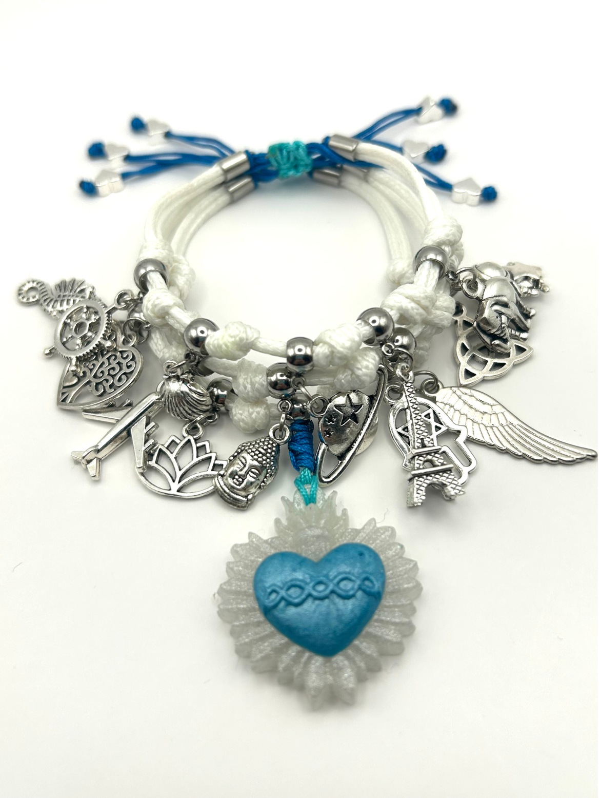 Bracelet with various charms including a blue heart, angel wings, and keys on a white background