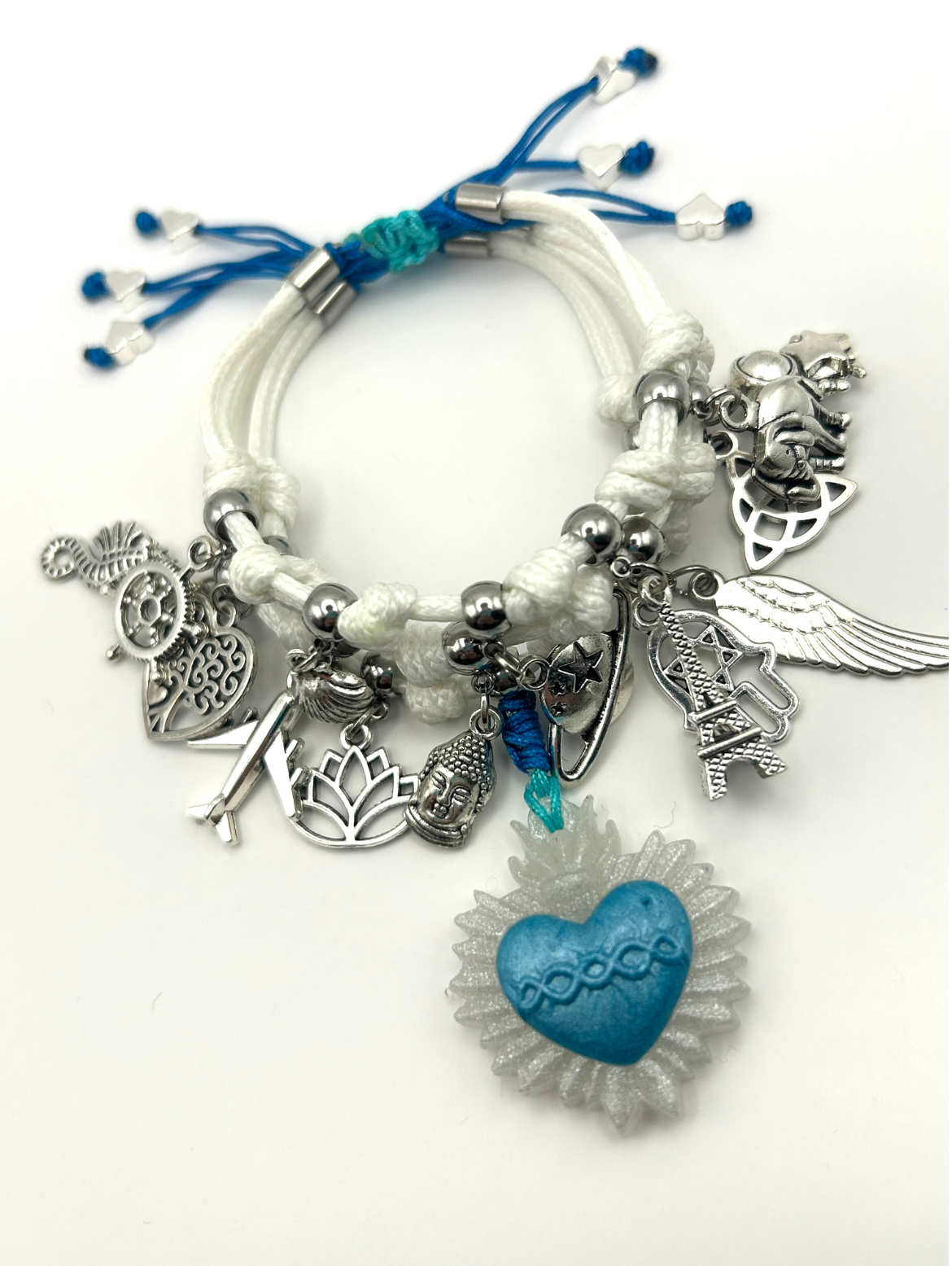 Bracelet with various charms including a blue heart and silver elements on a white background