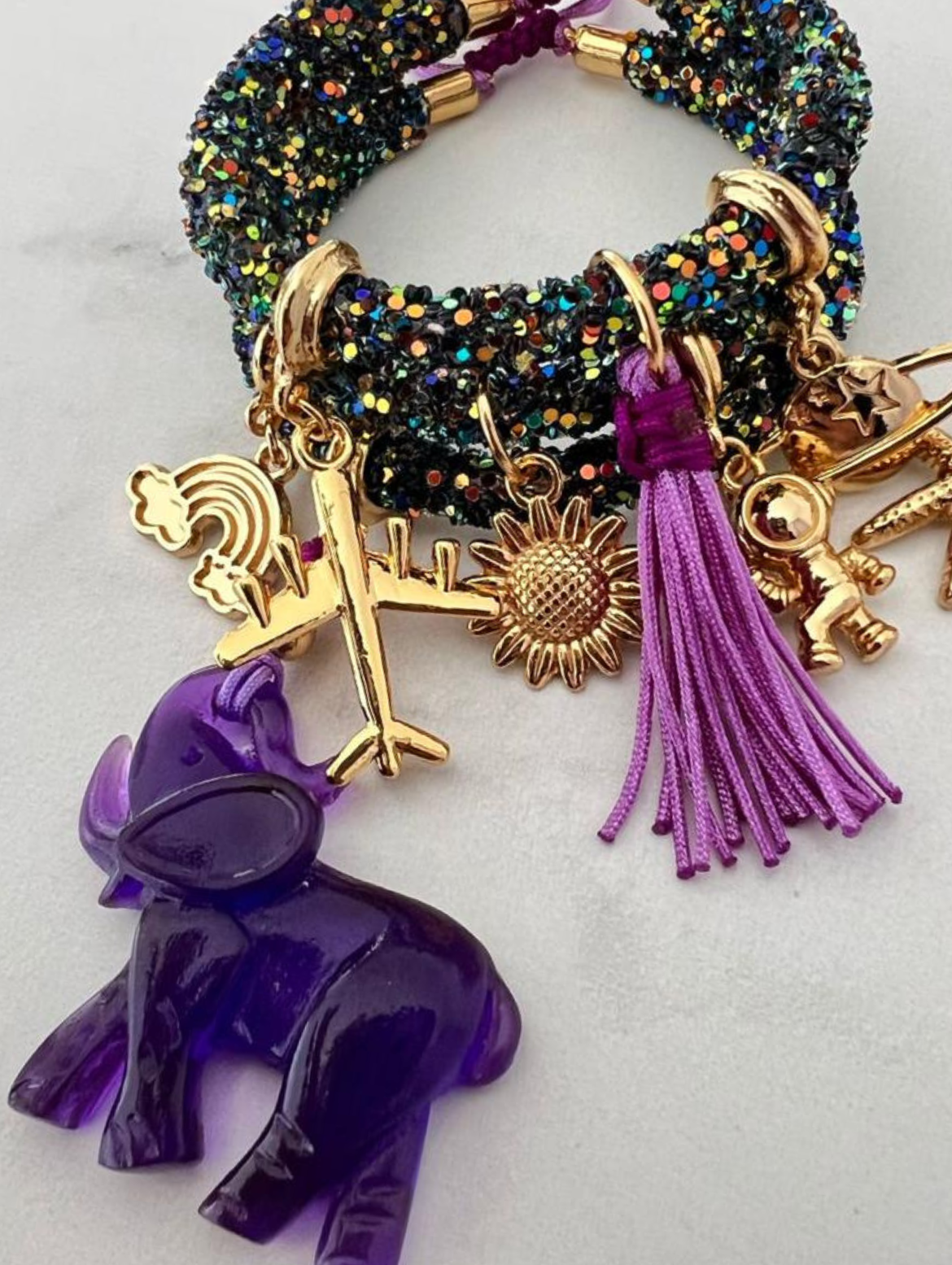 Dunkelgrünes, mehrfarbiges Strassarmband mit lila Elefanten und goldenen Glücksbringern