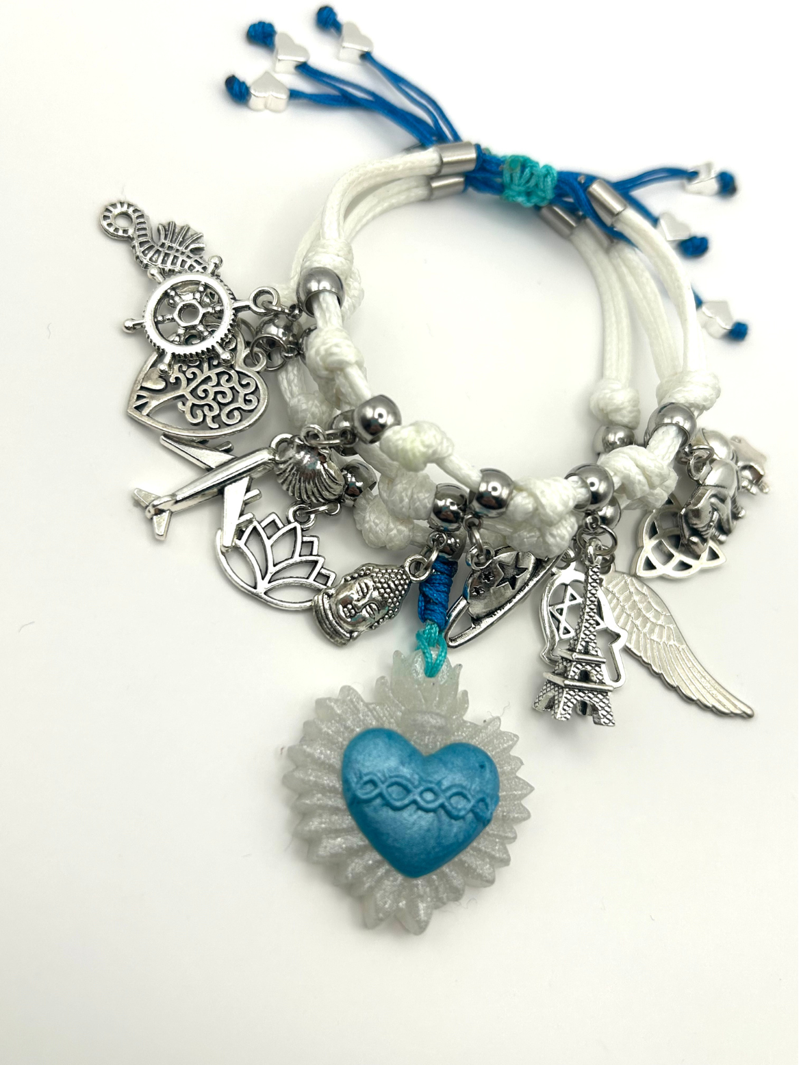 Bracelet with various charms including a blue heart, silver gears, and other decorative elements on a white background.