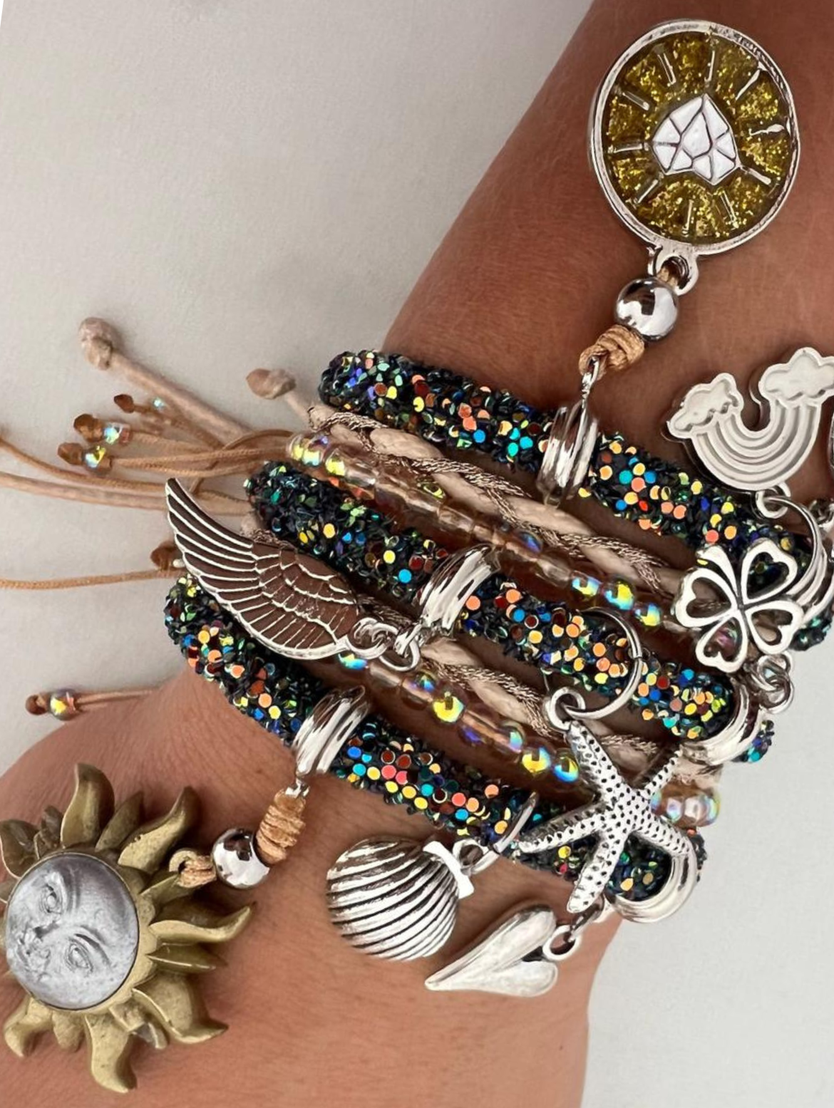 Dunkelgrünes, mehrfarbiges Armband, grau-goldene Sonne, runder goldener Diamant und silberne Glücksbringer.