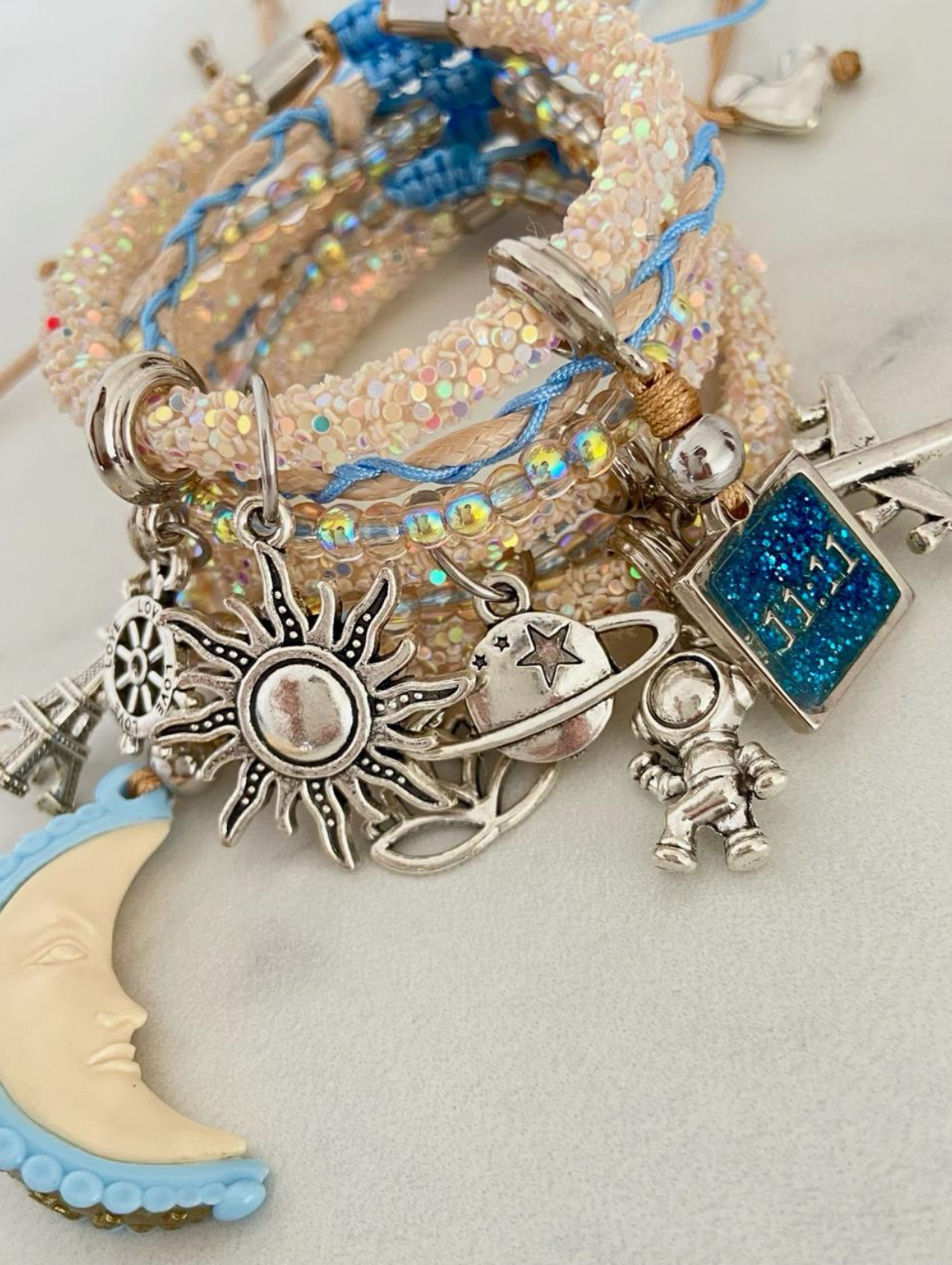 Armband mit perlweißen Strasssteinen, hellblauem Mond, 11:11 und silbernen Glücksbringern.