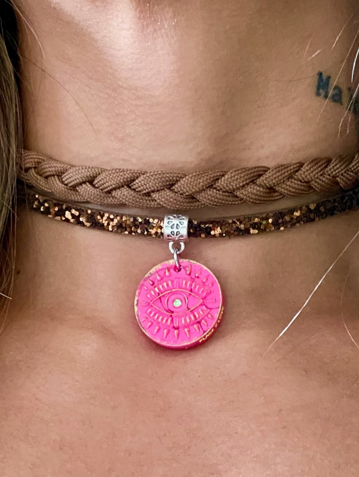 Doppelband-Halsband mit mystischem rosa Augenanhänger und funkelnden Details.