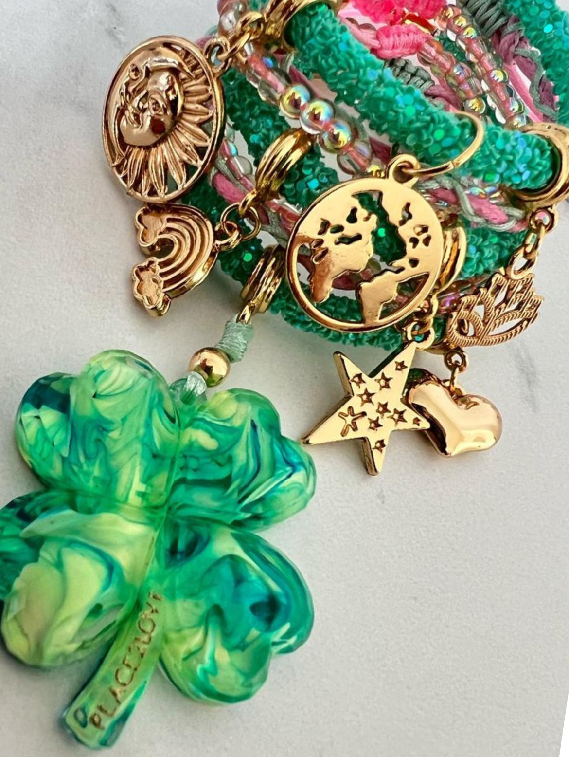 Grünes Strassarmband mit neongrüner Nelke, rosa Kordel und goldenen Glücksbringern